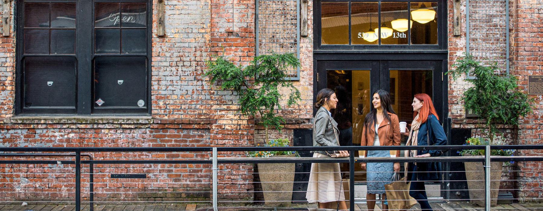 three women standing in front of a building