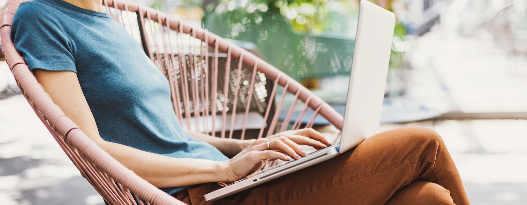 a person sitting on a chair using a laptop