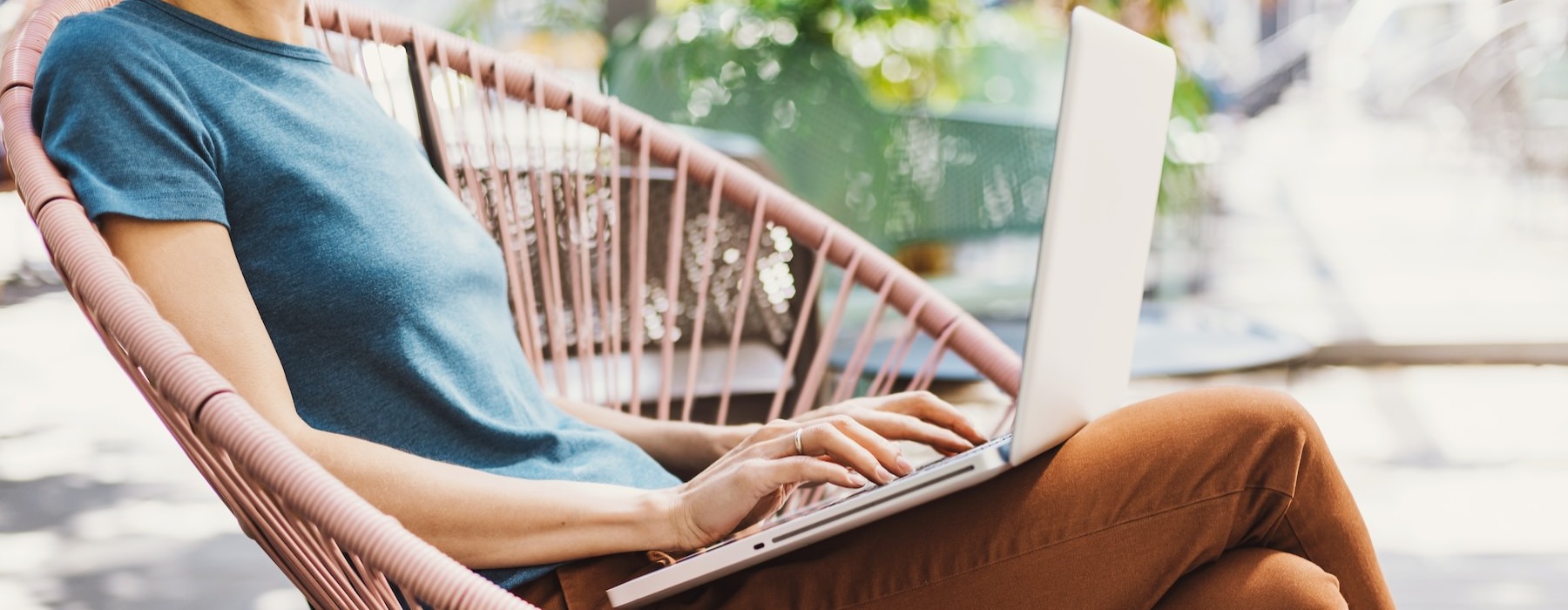 a person sitting on a chair using a laptop
