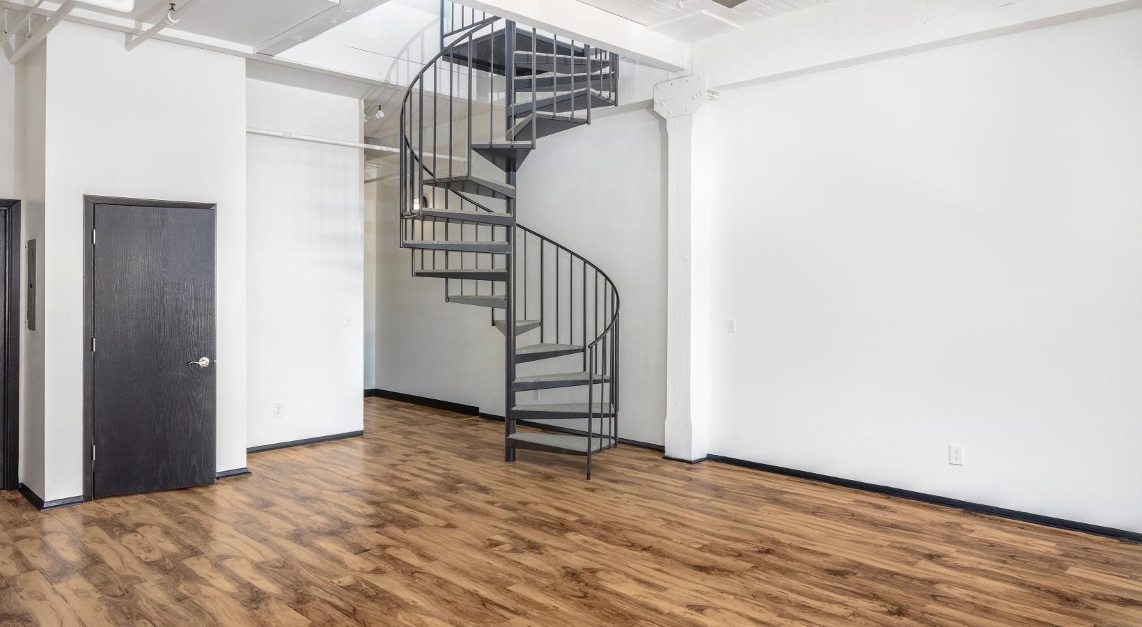 Wide open living areas perfect for entertaining a living room with a staircase and a wood floor