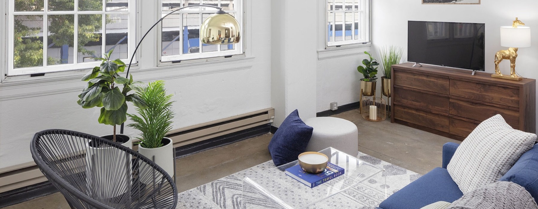 a living room with a couch, a tv and a large window