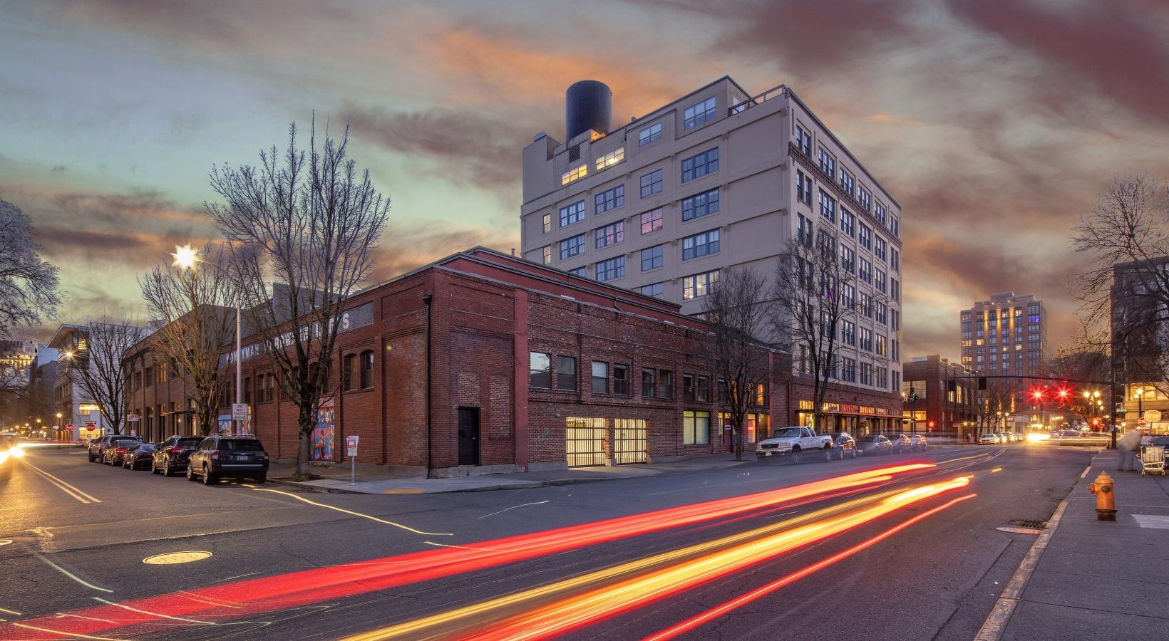 Settle into comfort at Honeyman Hardware Lofts a street with cars and buildings on the side