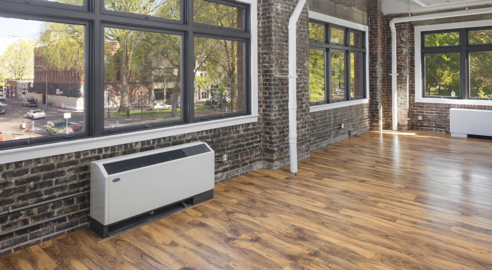 Beautiful living spaces with natural lighting a room with wood floors and brick wall